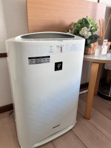 a white refrigerator sitting next to a table at 蓮子川Room in Hamamatsu