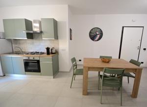a kitchen and dining room with a wooden table and chairs at La Casa di Zefiro in Santa Flavia