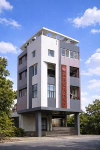a white building with a red sign on it at HOTEL RR Grand in Varanasi