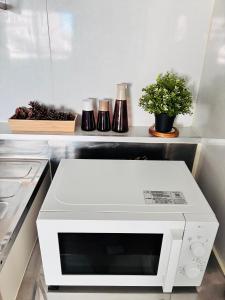 a white microwave oven sitting in a kitchen at 蓮子川Room in Hamamatsu