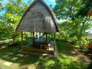 a small gazebo with a grass roof at Singa Villas in Ungasan