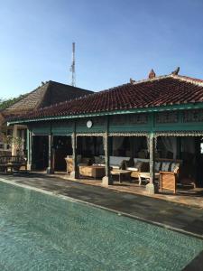 a building with a swimming pool next to a house at Singa Villas in Ungasan +9 photos