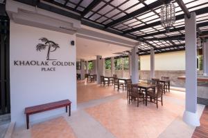 a restaurant with tables and chairs and a sign that reads khak goblin palace at Khaolak Golden Place in Khao Lak