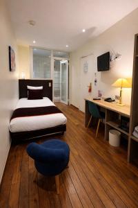 a bedroom with a bed and a desk and a chair at Hotel Pax Opera in Paris