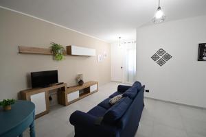 a living room with a blue couch and a tv at La Casa di Zefiro in Santa Flavia