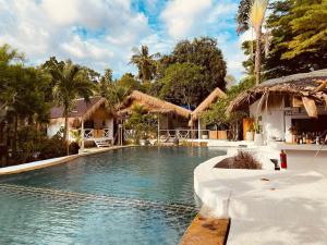 a swimming pool in front of a house at Sama Beach Resort by Munchies Resort in Ban Tai