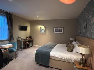 a hotel room with a bed and a desk and chair at Old Swan in Skipton
