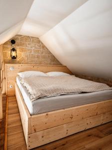 a bed in a room with a brick wall at Trapani house & camp in Růžová