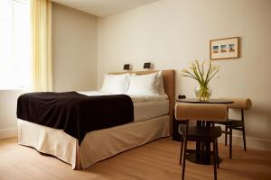ein Schlafzimmer mit einem Bett und einem kleinen Tisch in der Unterkunft Mjólk Hotel in Reykjavík