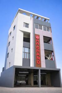 a tall white building with a red sign on it at HOTEL RR Grand in Varanasi
