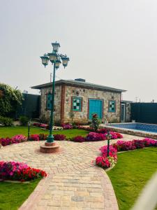 a brick building with a light pole in a garden at Mastiff Citadel RC in Chūharpur