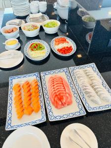 a table topped with plates of food with sushi at Pratunam Atrium Hotel in Bangkok +53 photos