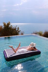 a woman laying on a raft in a swimming pool at Arcadia anyin qingshan hotel in Dali Shuanglang