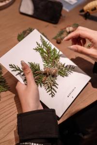 a person holding a piece of paper with a christmas tree at Arcadia anyin qingshan hotel in Dali Shuanglang