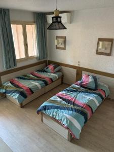 a bedroom with two beds and a window at Studio Rez de jardin coté piscine - Clim in Saint-Raphaël