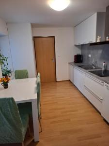 a kitchen with a table and chairs and a counter top at Apartmán u parku in Prostějov