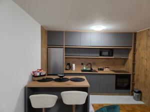 a kitchen with a counter and two stools in it at Apartman Anja'K in Doboj +2 photos