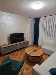 a living room with a tv and a couch and a table at Apartman Anja'K in Doboj