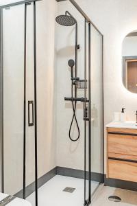 a shower with a glass door in a bathroom at Elcano Suites in Seville +9 photos