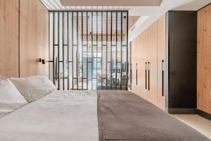 a bedroom with a bed and a large window at Elcano Suites in Seville