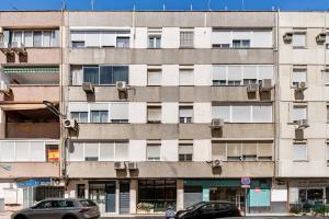 an apartment building with cars parked in front of it at Elcano Suites in Seville