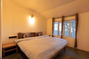 a bedroom with a large bed and a window at Outside Space Resorts in Lovedale