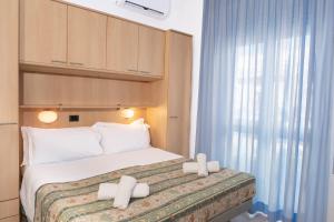 a hotel room with a bed with white pillows at Nautilus Hotel in Bellaria-Igea Marina