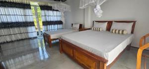a bedroom with a large bed and two windows at Sigiriya River Side Resort in Sigiriya