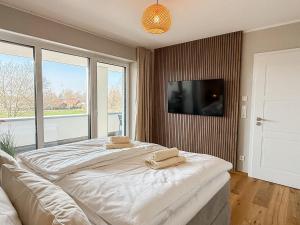 a bedroom with two beds and a flat screen tv at Ferienwohnung Seeglück am Dümmer See in Lembruch