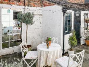 a table and chairs in a courtyard with a table at Bay Cottage in Ripon
