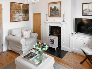 a living room with a fireplace and a tv at Bay Cottage in Ripon