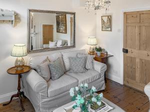 a living room with a couch and a mirror at Bay Cottage in Ripon