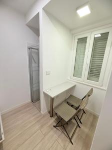 a desk and a chair in a white room at Colombo 365 in Civitanova Marche +13 photos