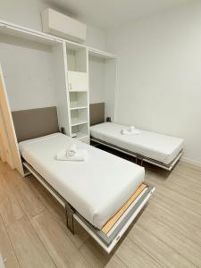 a room with two beds and shelves in it at Colombo 365 in Civitanova Marche