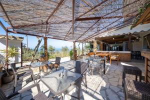 a patio with tables and chairs under a roof at Pension Elena in Ágios Nikólaos