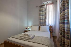 a bedroom with a bed with towels on it at Green Blue Kardamyli in Kardamyli