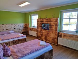 two beds in a room with green walls and windows at Gaststätte Zur Hahnenquelle in Kirchhundem