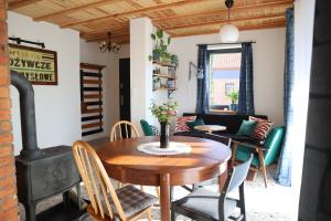 a dining room with a table and a wood stove at Smugi Dom Gościnny in Lipowiec