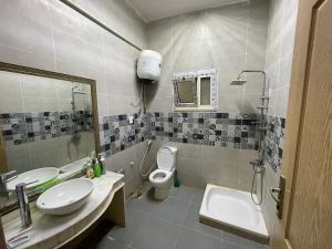 a bathroom with two sinks and a toilet and a mirror at Private Bella Rum Villa with Garden in Marsa Matruh +17 photos
