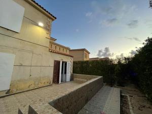 a building with a staircase leading to a door at Private Bella Rum Villa with Garden in Marsa Matruh