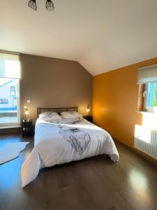 a bedroom with a large bed in a room at Le Daguet pour 8 in Florenville