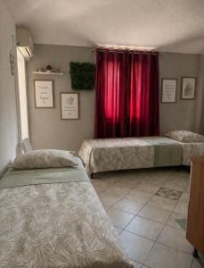 a bedroom with two beds and a red curtain at Pino Center in Pino Torinese