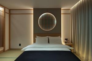 a bedroom with a large bed and a mirror at Anook Ryokan Hotel Daejeon Yuseong in Daejeon