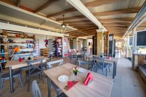 a restaurant with tables and chairs in a room at Pension Elena in Ágios Nikólaos