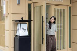 a woman standing in front of a building at Anook Ryokan Hotel Daejeon Yuseong in Daejeon +196 photos