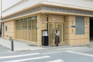 a woman standing in the doorway of a building at Anook Ryokan Hotel Daejeon Yuseong in Daejeon