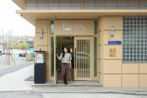 a woman standing in the doorway of a building at Anook Ryokan Hotel Daejeon Yuseong in Daejeon