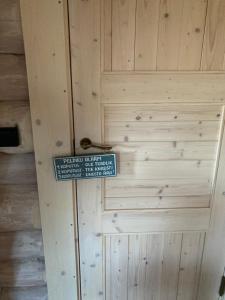 a sign on a wooden door with a sign on it at Kenu Saunamaja in Haapsalu