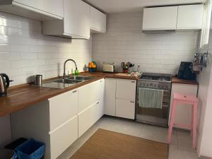 a kitchen with white cabinets and a sink and a stove at Casa del Rellotge in Benifallet