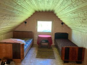 a room with two beds and a table in a room at Kenu Saunamaja in Haapsalu